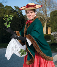 Carrying holly for seasonal decorations, Amy Griffin re-creates the pose in the eighteenth-century engraving December seen in Christmas in Prints.