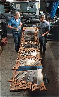 George Wilson, left, and Jon Laubach with a table full of saws in the modern shop where they make many of the tools for Historic Trades.