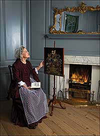 Sandy Bradshaw, behind a fire screen, avoids the heat. 