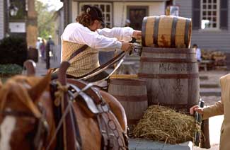 Interpreter Dan Hard, delivering goods to Williamsburg’s Raleigh Tavern, draws a mug of wine without falling off the wagon.