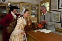 From left, Will Damron, Kate Kovach, and Dennis Watson, as Alexander Purdie, in the Post Office store, with reproductions for sale.