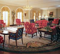 The lobby, with period seating, a chandelier, and fireplace.