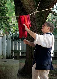 Weaver and dyer Max Hamrick checks the red hues of the wool.